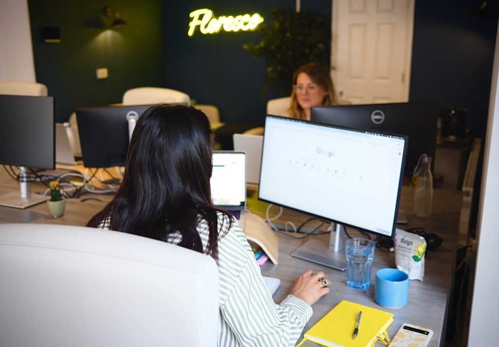 Photograph shows Floresco's media team on their computers in an office environment.