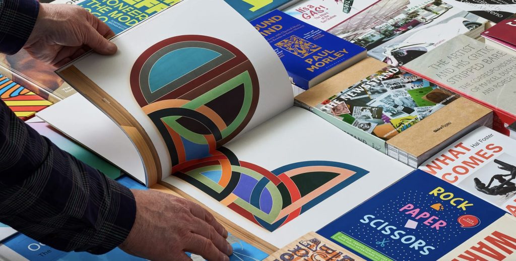 Photograph of selection of books, from Books About Art, being flicked through.